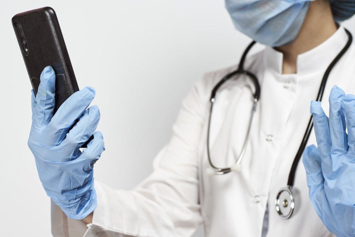 doctor-wearing-gloves-face-mask-holding-smartphone.jpg